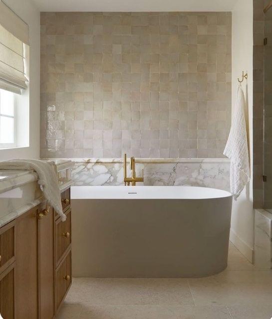 Apron-front stone tub with Zellige tile wall