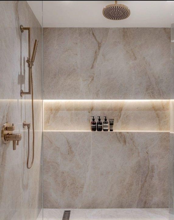 Walk-in shower with illuminated stone niche