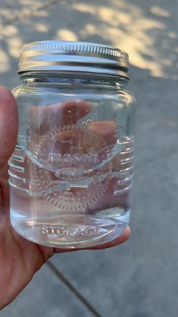 Clear glass jar of water held up to the light