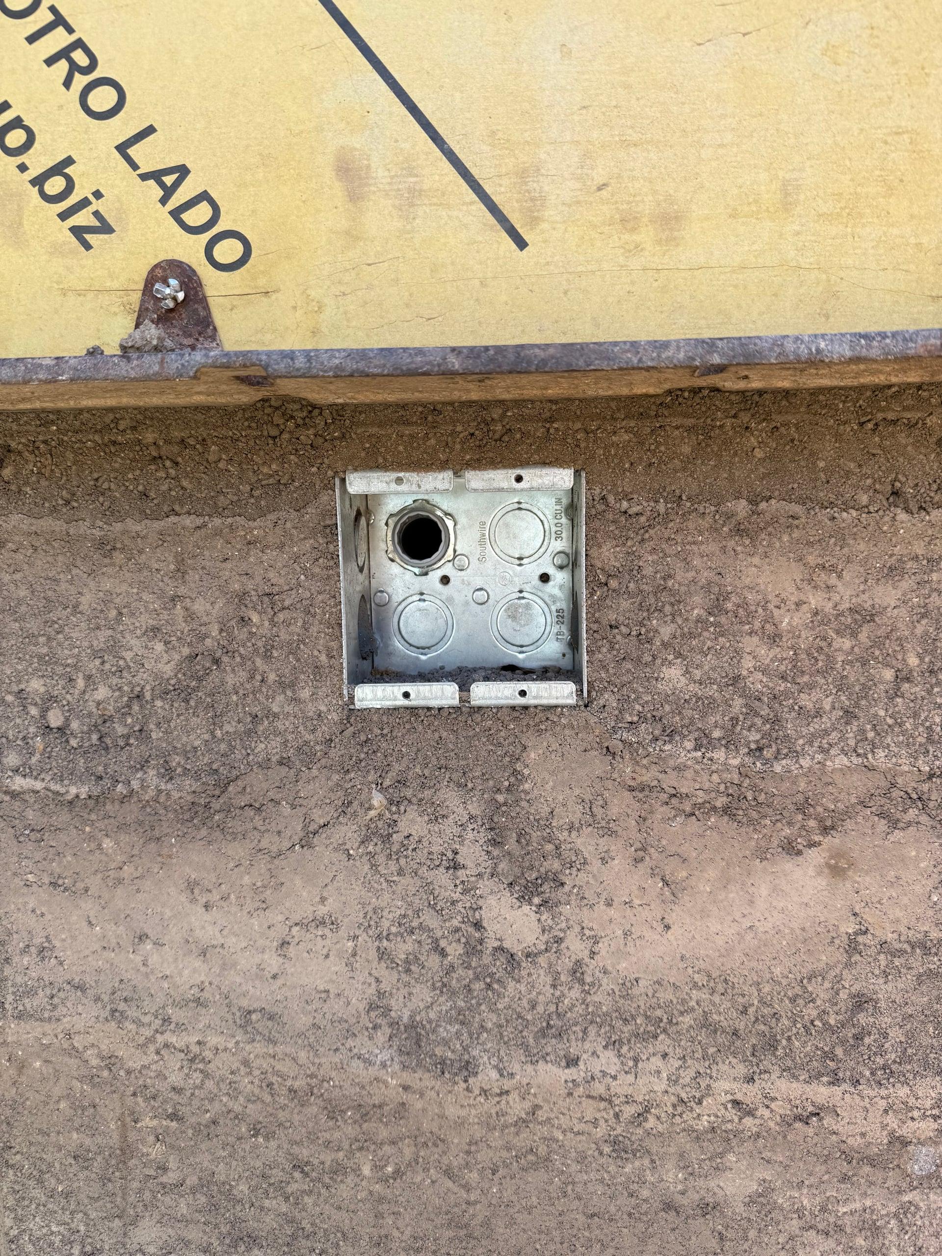 Electrical box cast directly into the rammed-earth wall