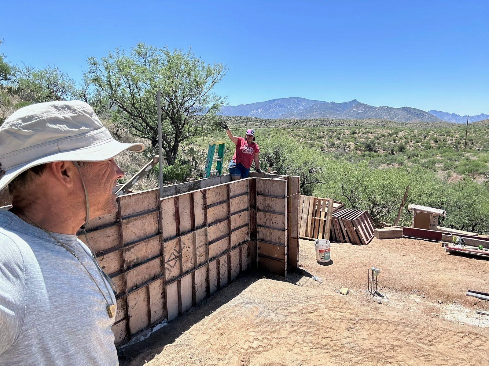 Brian Johnson beside a run of braced rammed-earth wall forms in the desert