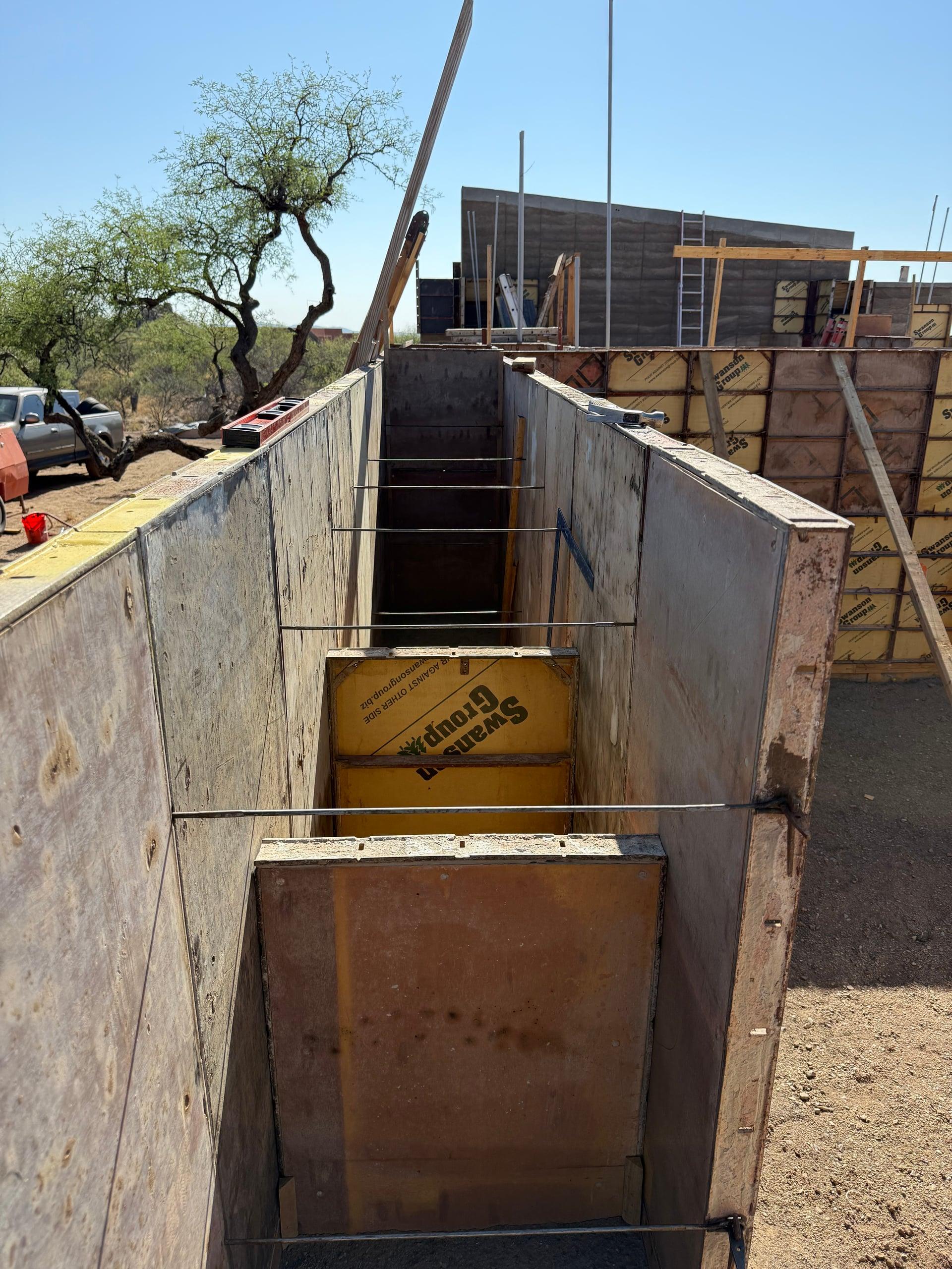Looking down a formed wall cavity with steel ties in place before ramming