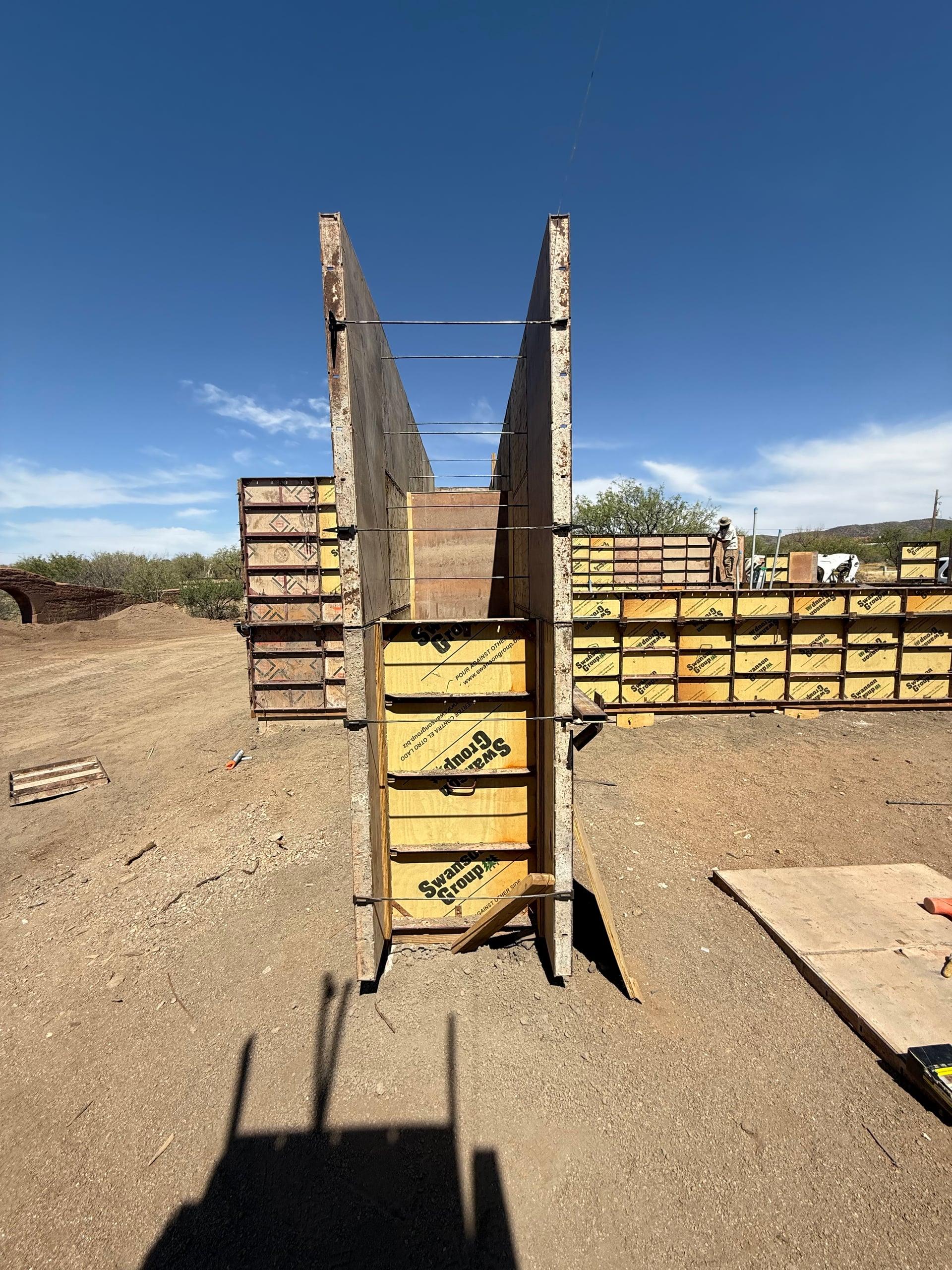 Rammed earth formwork panels braced and ready for the next lift