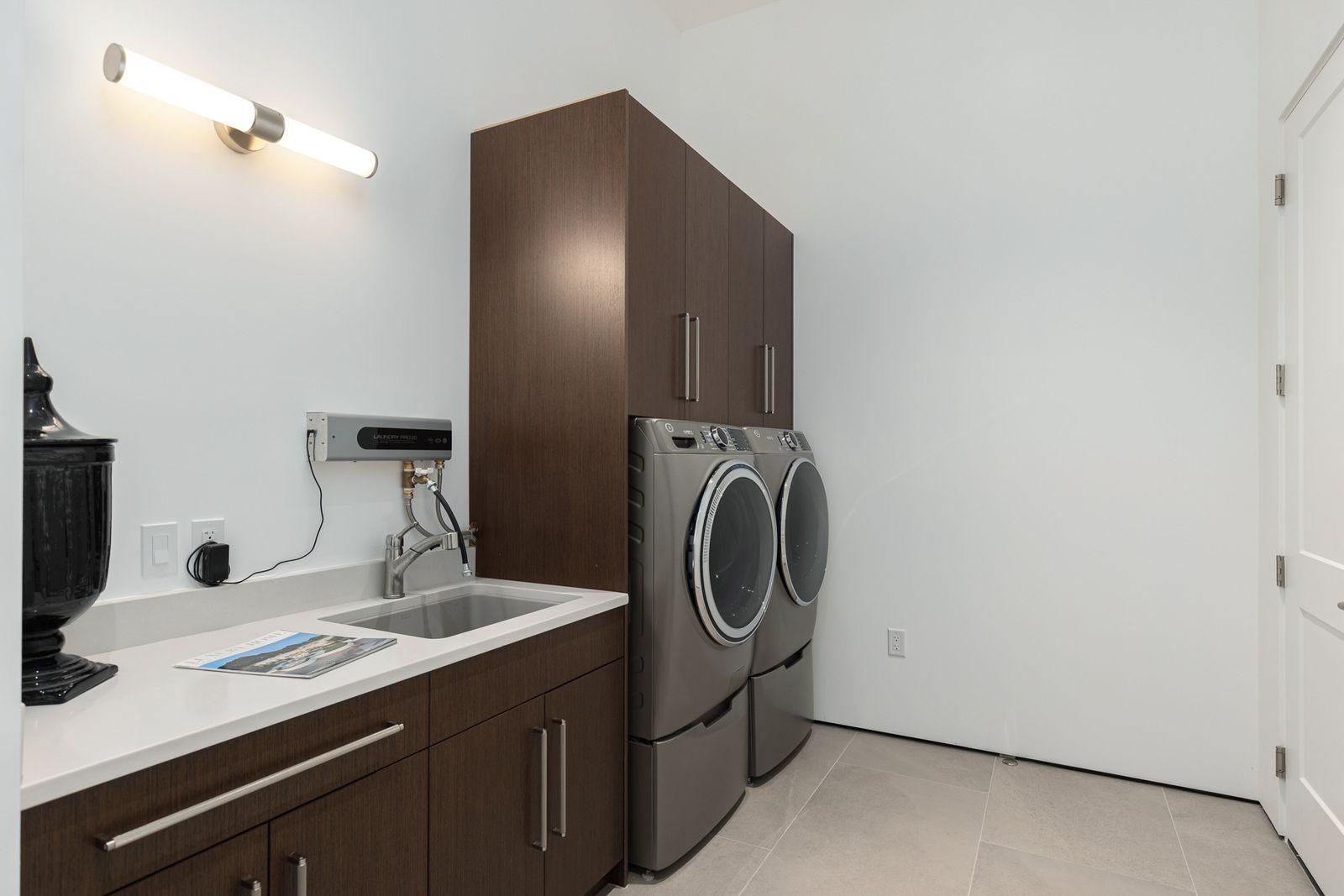 Laundry room with cabinets, a sink, and front-load washer and dryer