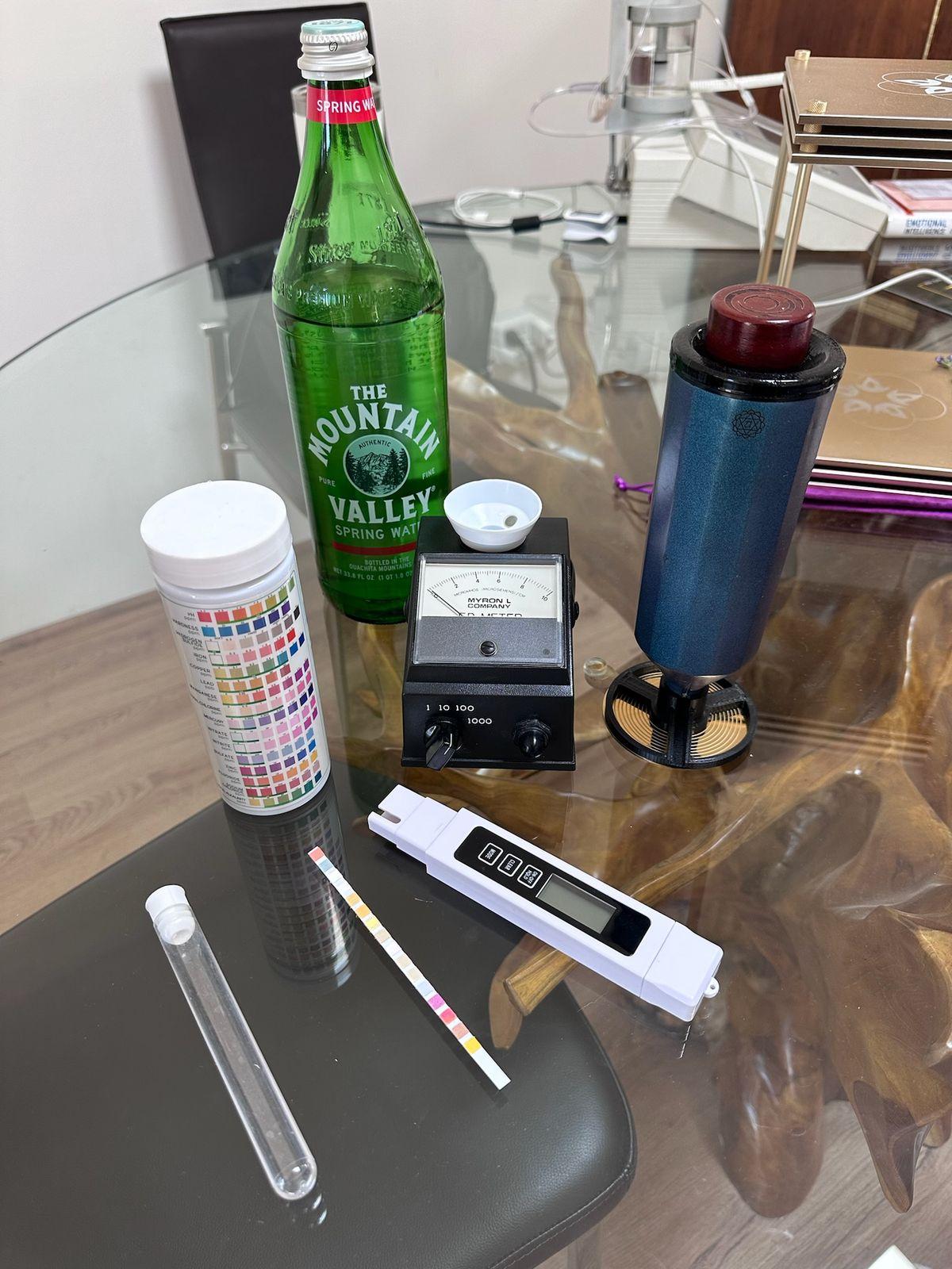 Water test strips, a TDS meter, and test vials on a table