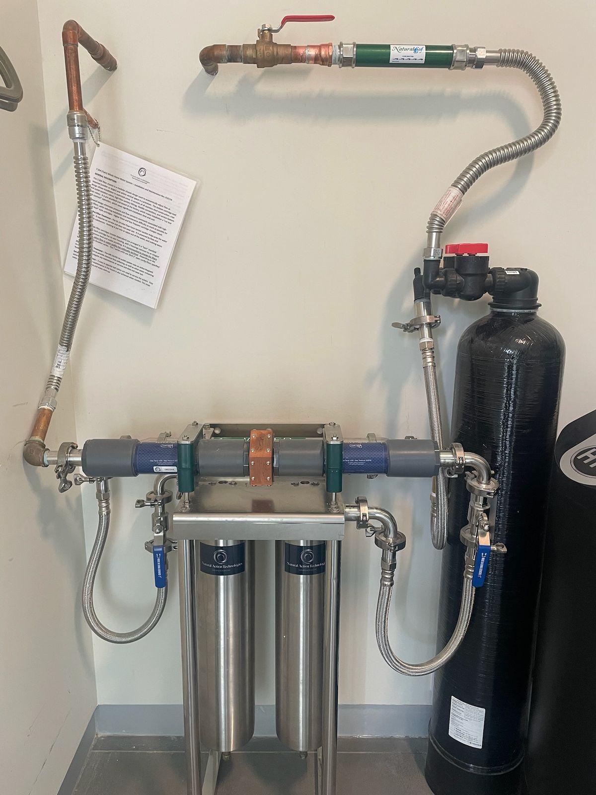 Two-vessel stainless water system on casters in a garage corner