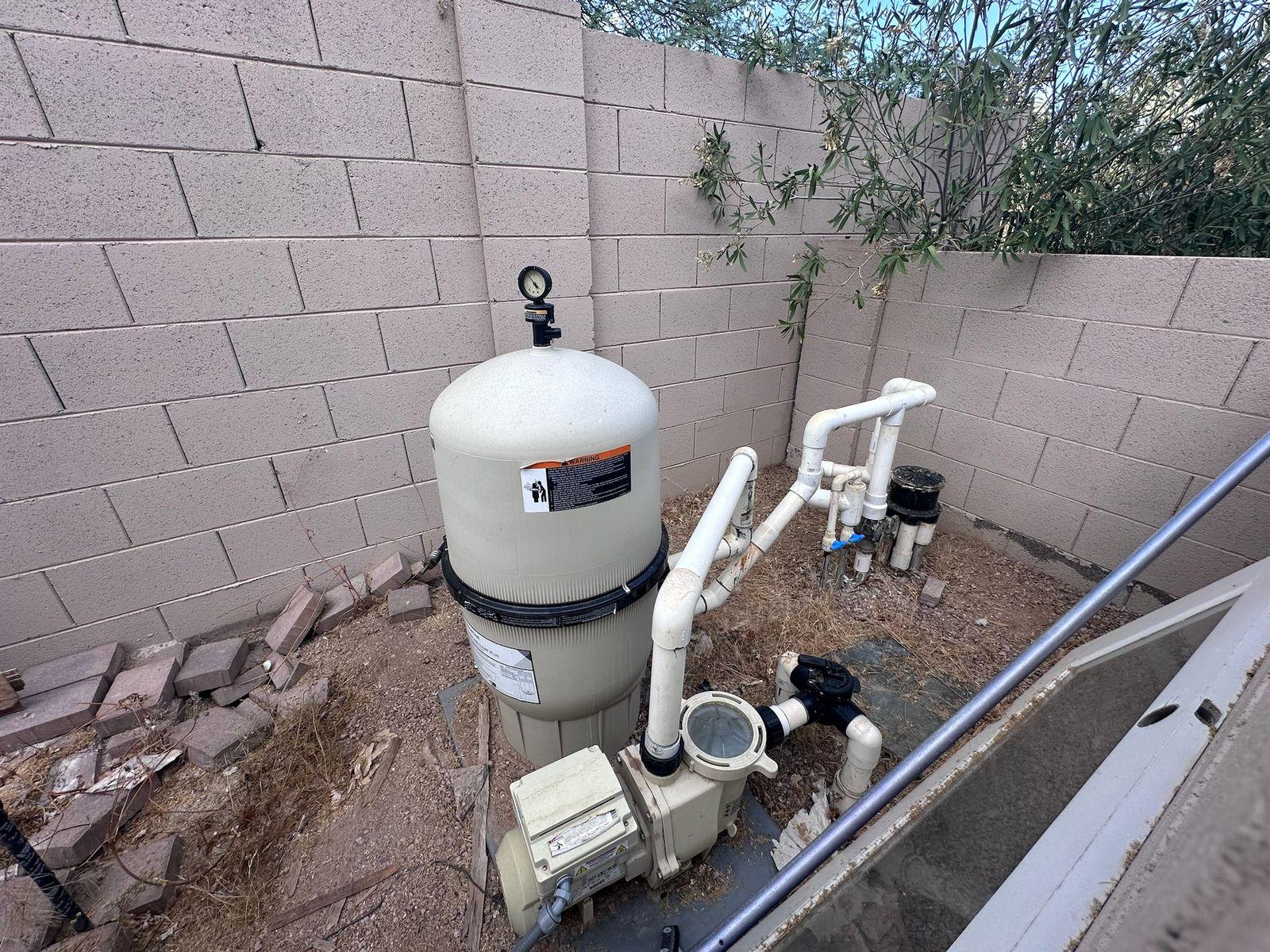 Pool filter and pump on an equipment pad beside a block wall