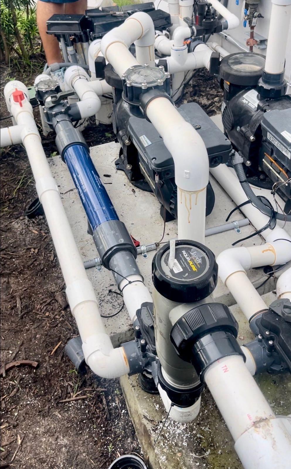 Pool equipment plumbing with a blue inline structured water unit on the line
