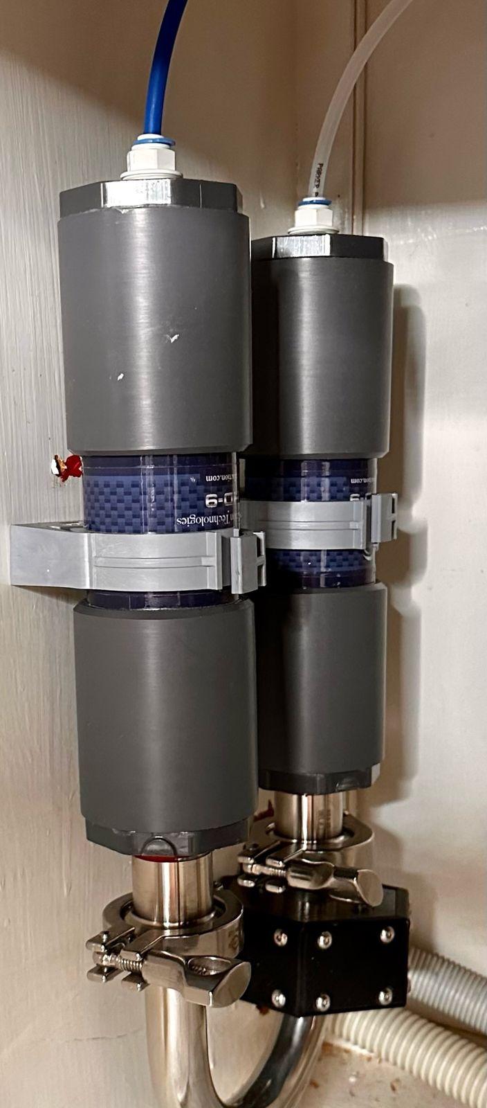 Two gray inline structured water units mounted vertically on a wall