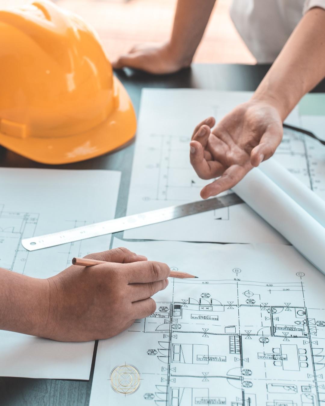 SENERGY360 design and build process: hard hat, ruler and pencil over house plans