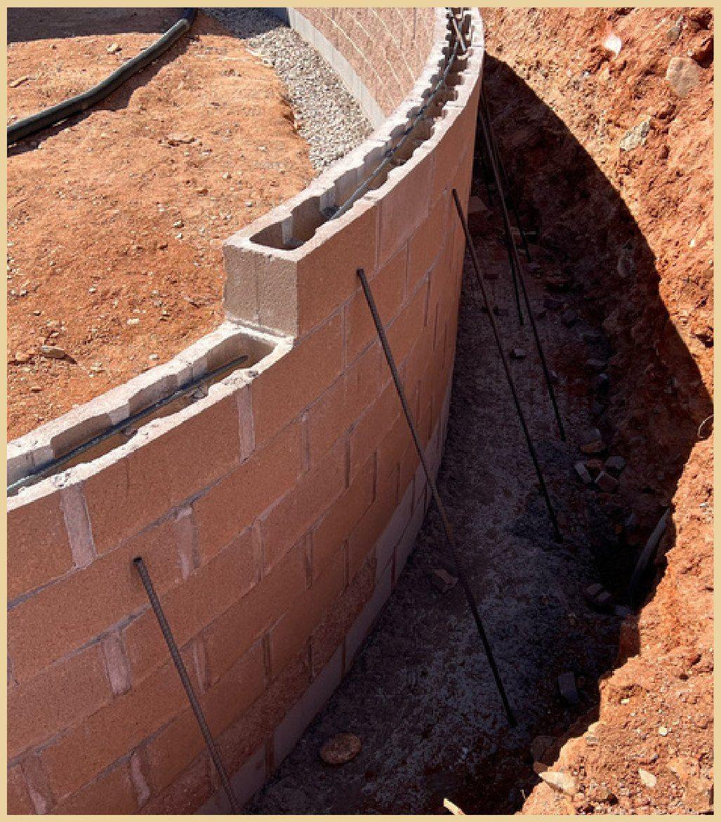 Curved below-grade foundation wall with waterproofing before backfill