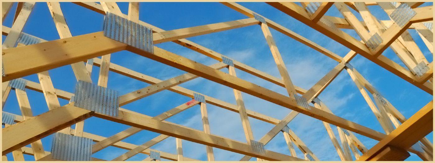 Open roof framing against a blue sky