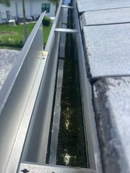 Roof gutter packed with wet debris