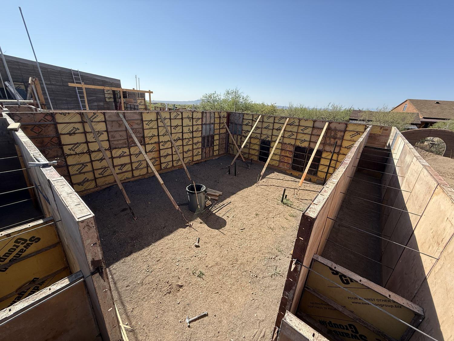 Open formwork bays running down the line of a wall on the desert site