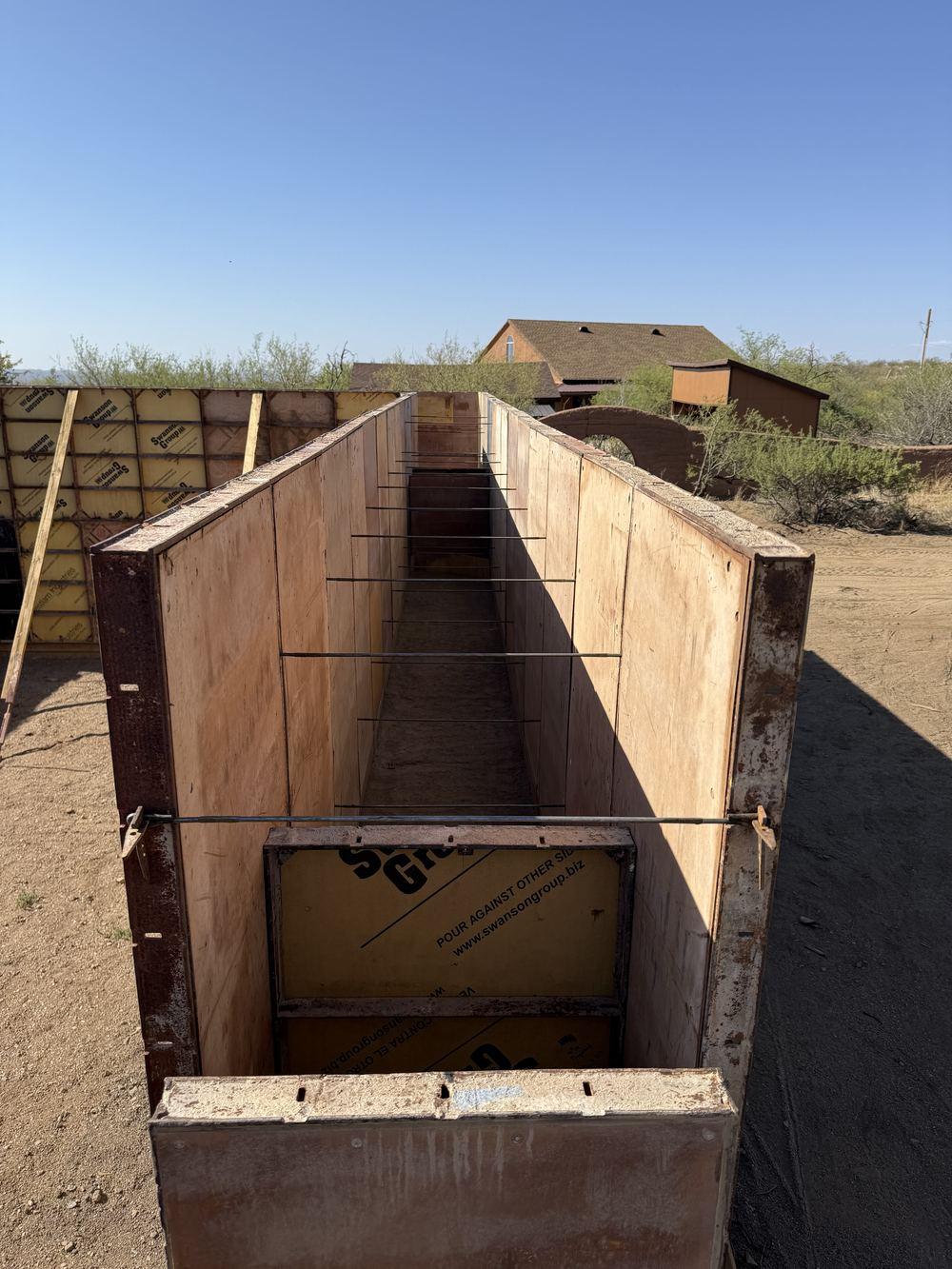 Braced rammed-earth formwork box open at the top, ready for the next lift