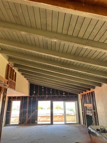 Remodel in progress: exposed ceiling beams and open wall framing around sliding glass doors
