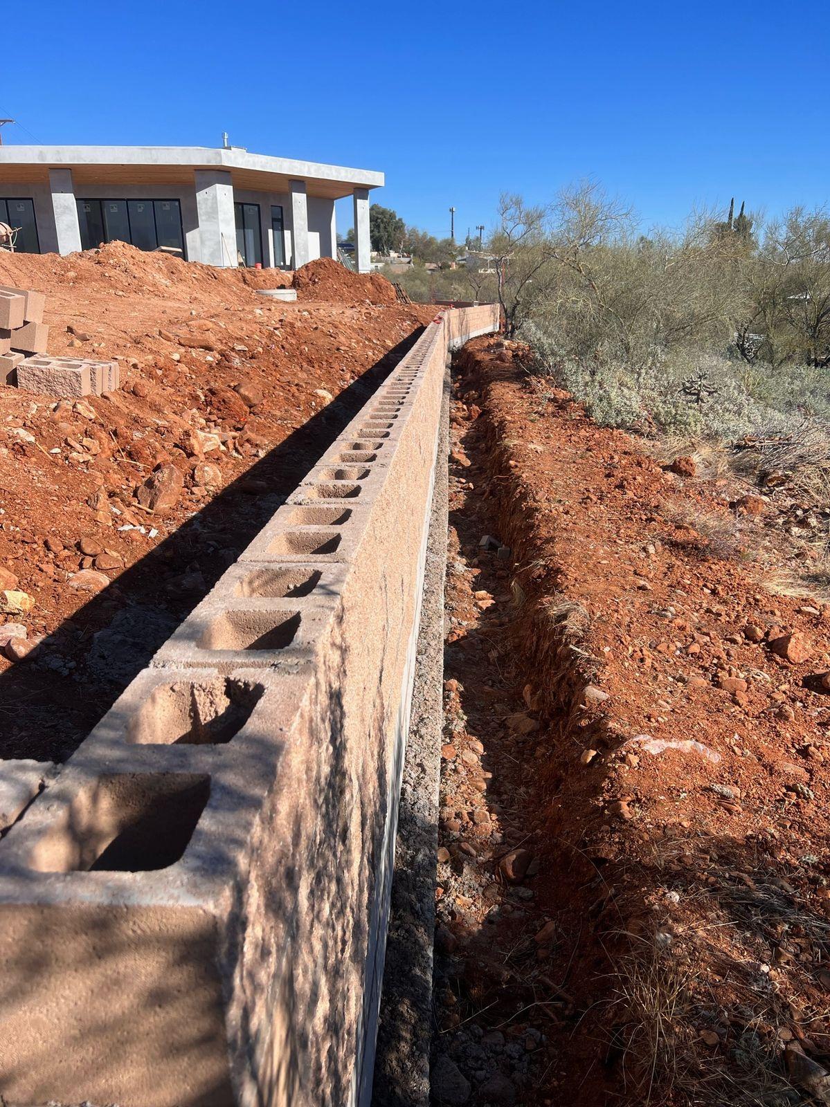 Block retaining wall footing in a trench