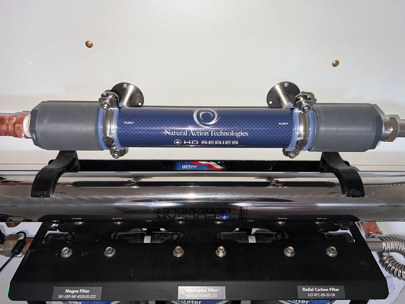 HD Series structured-water unit mounted above an ultraviolet chamber and a manifold labeled Magna Filter, Interceptor Filter, and Radial Carbon Filter