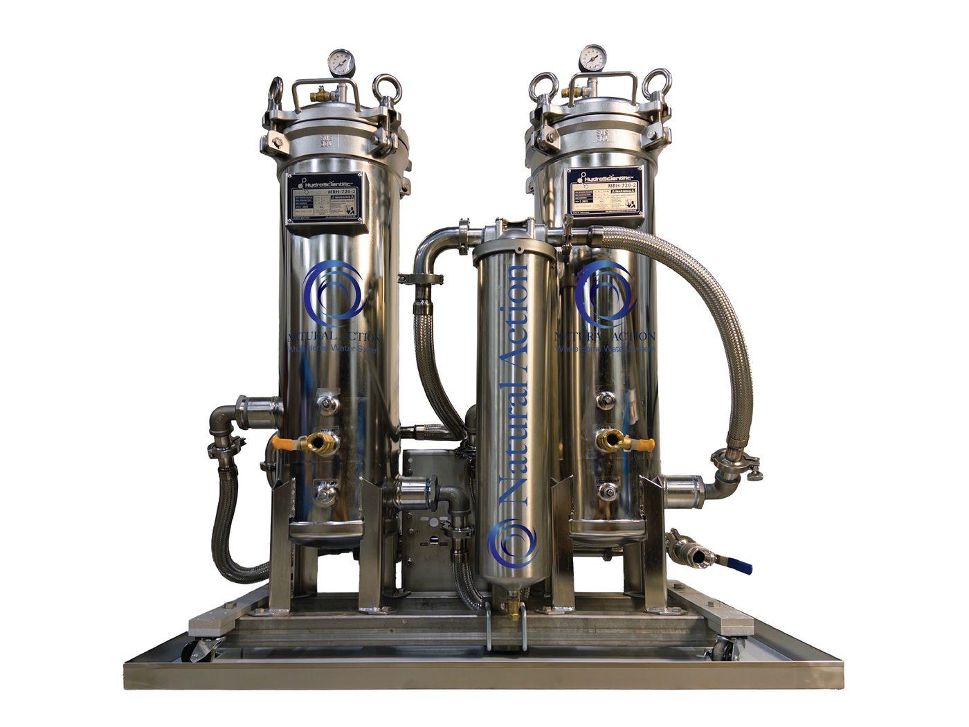 Finished whole-home structured water skid: two stainless filter vessels with gauges, plumbed on a caster-mounted stainless base