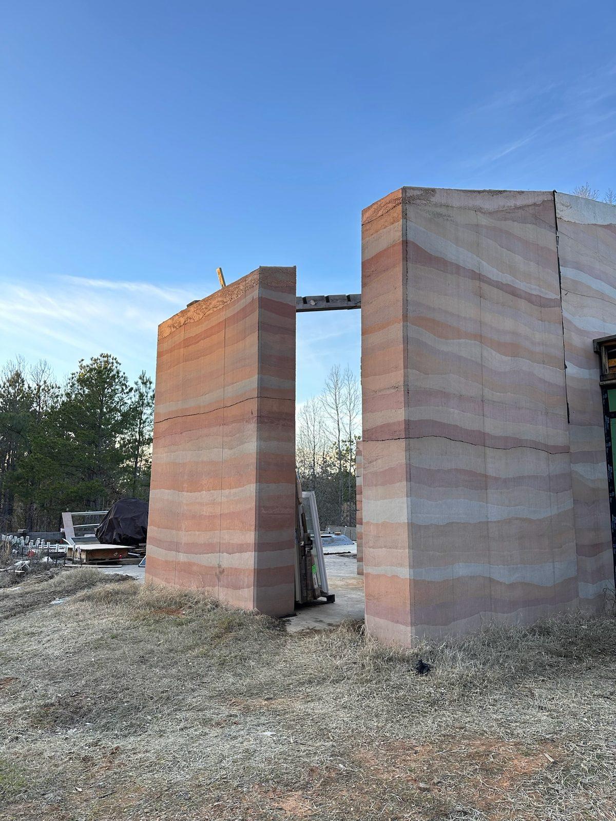 Two rammed earth columns framing an opening
