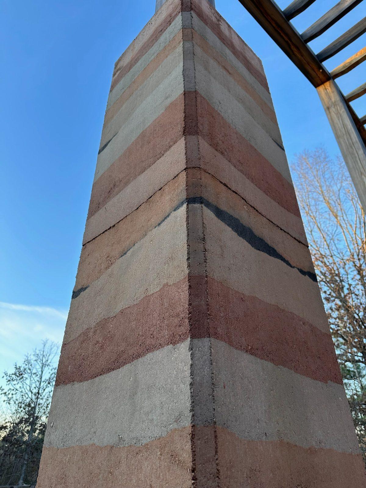 Looking up a tall striped rammed earth column
