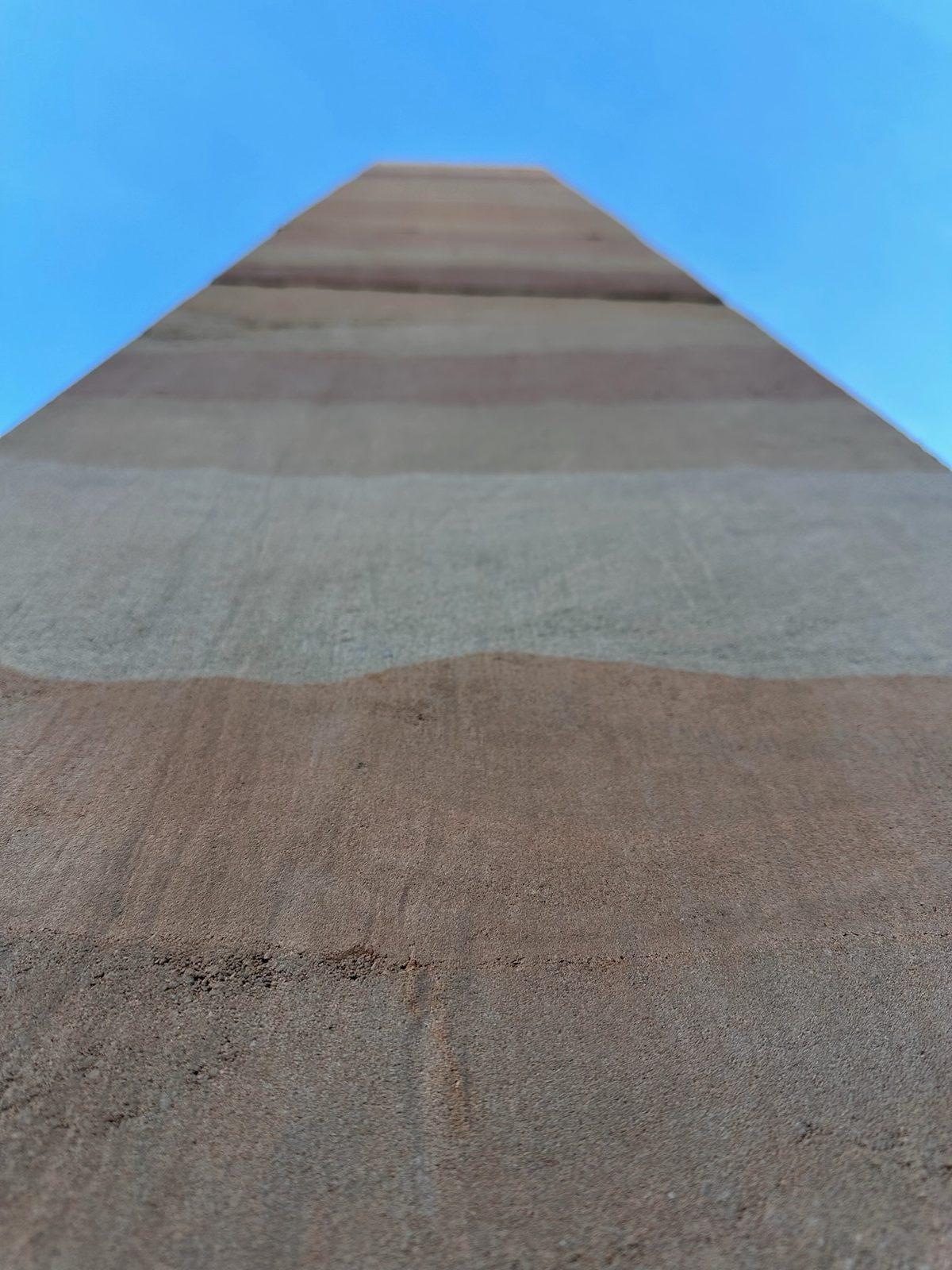 Top edge of a rammed earth wall against the sky