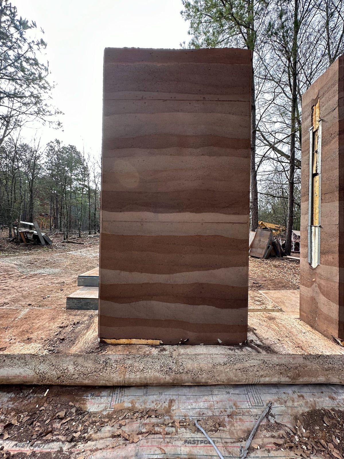 Freestanding rammed earth wall panel on its footing
