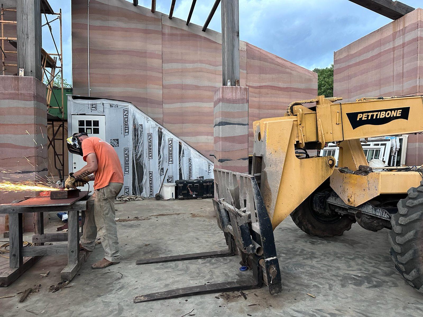 Crew cutting and setting forms beside a telehandler